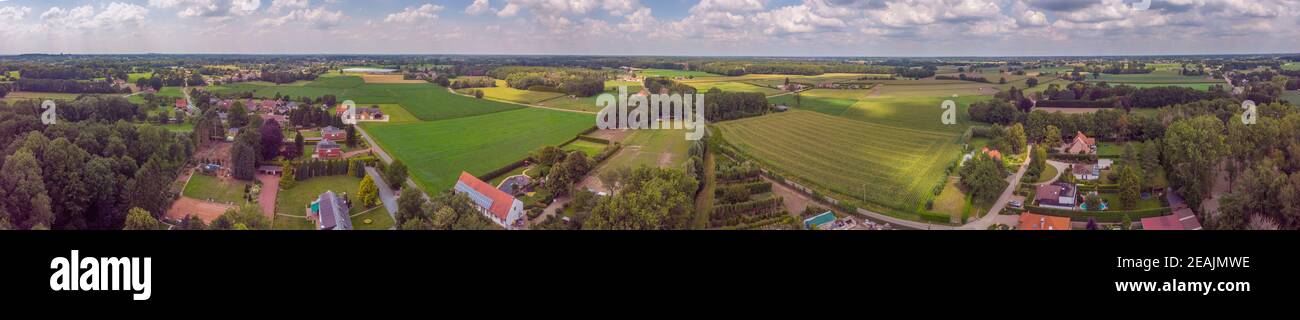 Vista panoramica aerea su una zona di campagna in Belgio con case e campi agricoli Foto Stock