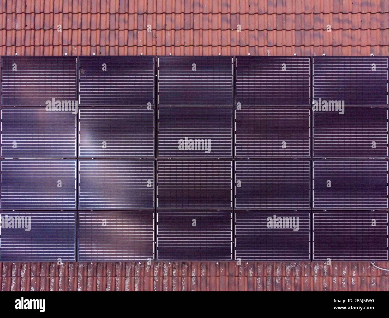 Pannelli solari neri in forma rettangolare installati su una piastrella tetto Foto Stock