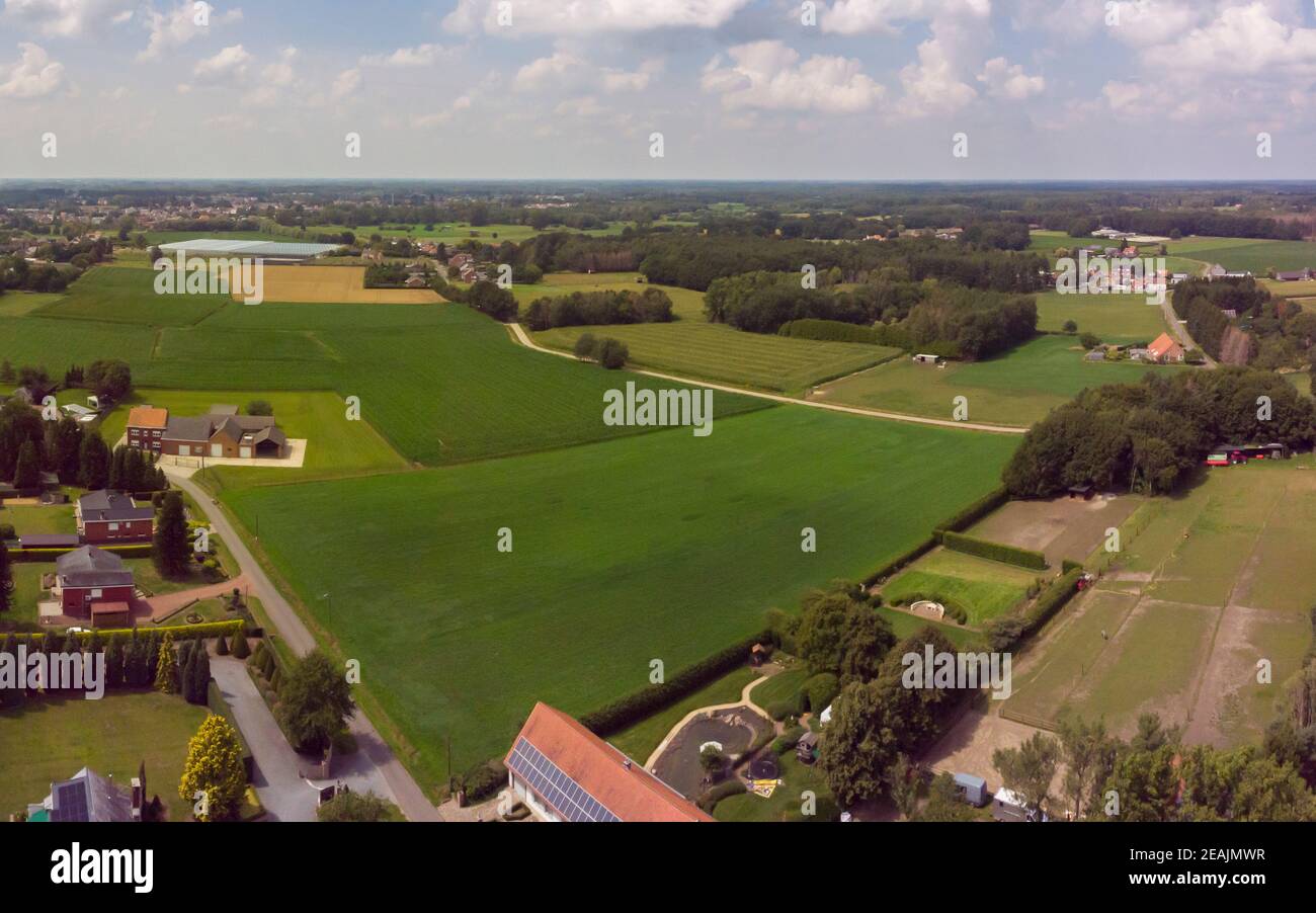 Vista panoramica aerea su una zona di campagna in Belgio con case e campi agricoli Foto Stock