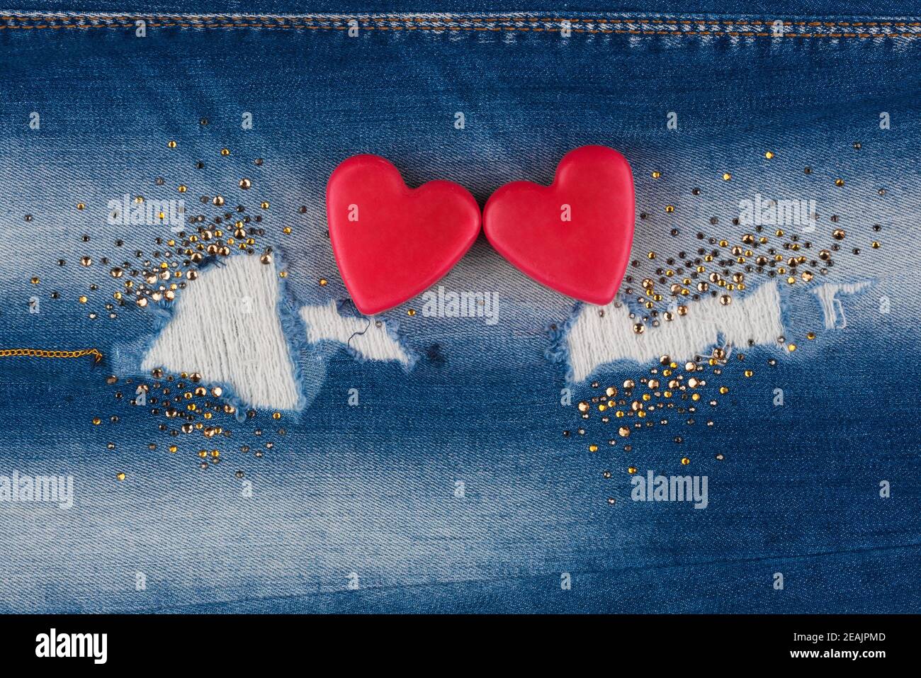 Il concetto di due cuori amanti che giacciono sui jeans Foto Stock