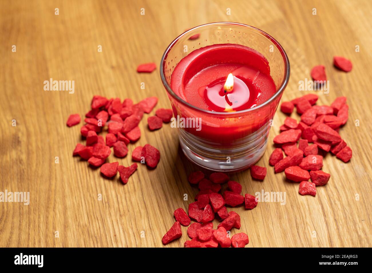 candela rossa bruciata su sfondo in legno. relax e benessere a casa e con benessere. concetto per un'atmosfera calda e confortevole Foto Stock
