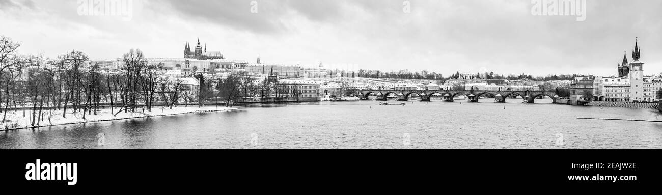 Inverno Praga Panoramica città con il Castello di Praga, il Ponte Carlo e il fiume Moldava. Repubblica Ceca. Immagine in bianco e nero. Foto Stock