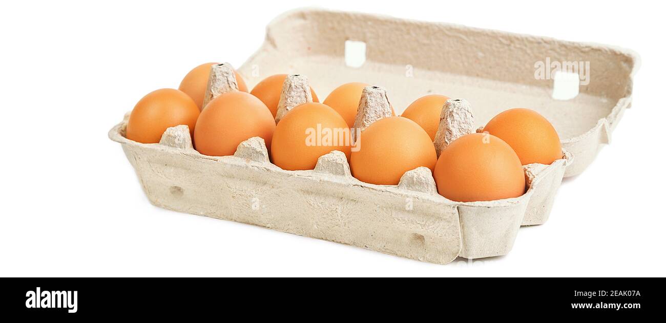 Dieci uova marroni in una scatola di cartone su fondo bianco, isolate. Foto Stock