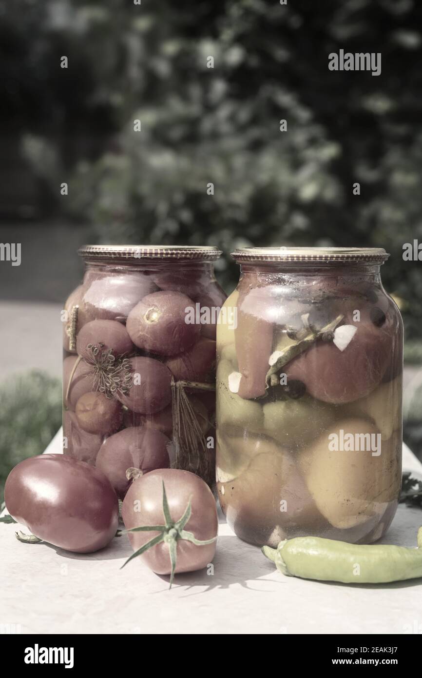 Pomodori e peperoni in scatola in vasetti di vetro. Foto Stock