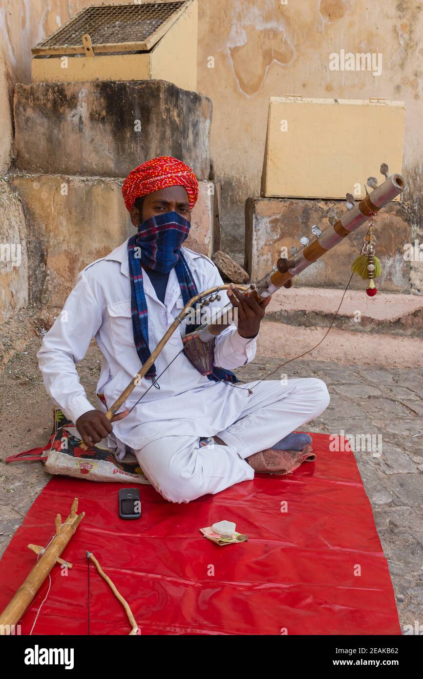 Uomo che gioca ravanahatha strumento folk fuori di Amber Palace, Jaipur, Rajasthan, India. Foto Stock