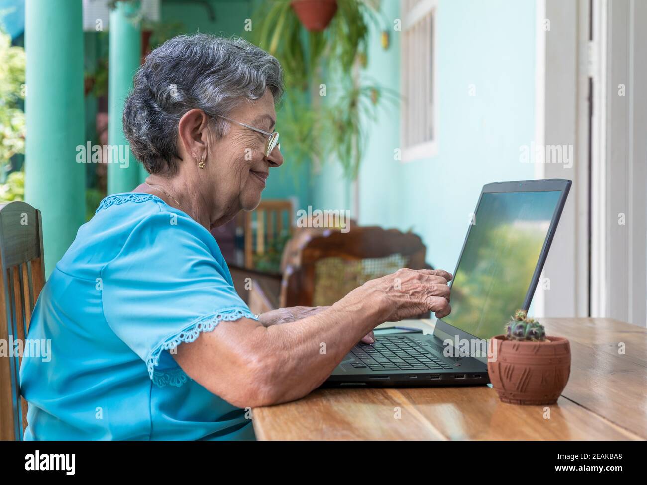 Donna anziana che lavora con un computer portatile moderno Foto Stock