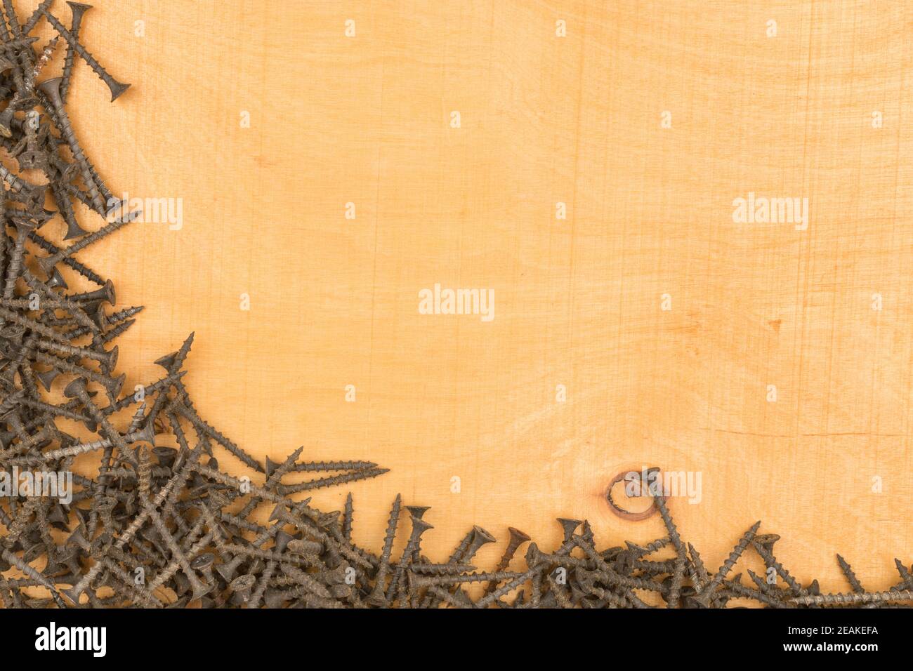 Telaio di nuove viti nere giacenti su una superficie di legno. Foto Stock