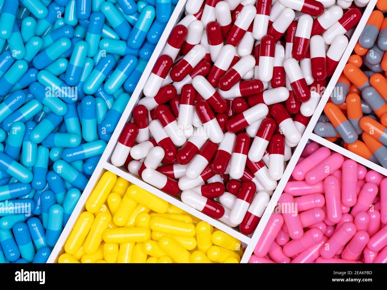 Vista dall'alto delle capsule colorate nell'industria farmaceutica. Sanità e medicina. Concetto farmaceutico. Capsule di vitamine e integratori. Struttura completa di pillole di capsule di colore brillante. Foto Stock