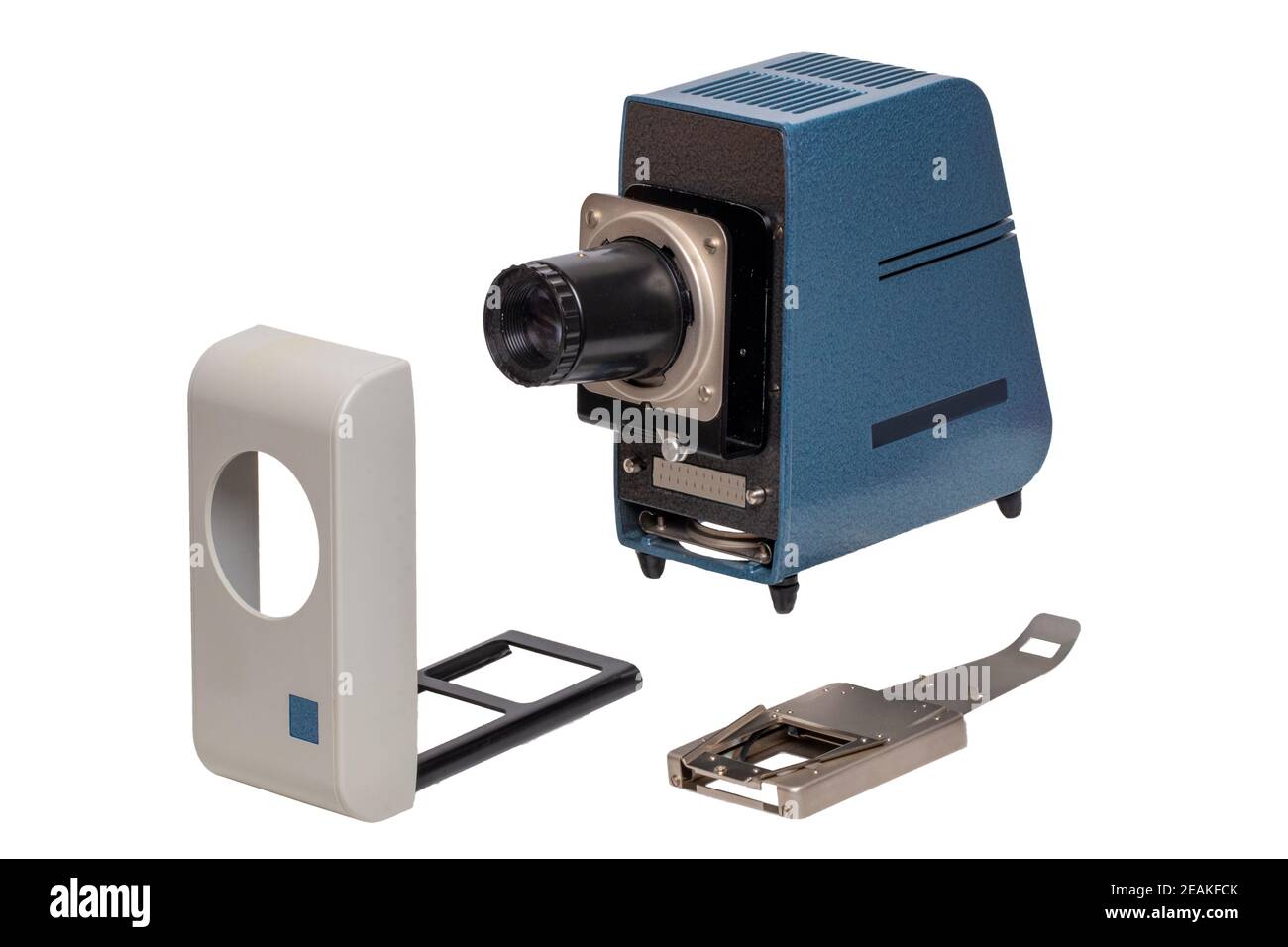 Proiettore d'epoca. Primo piano di un vecchio proiettore grigio blu per la visualizzazione di diapositive e strisce di pellicola isolate su uno sfondo bianco. Il proiettore è composto da una lampada, una lente, un coperchio e un dispositivo di sostituzione delle diapositive. Macro. Foto Stock