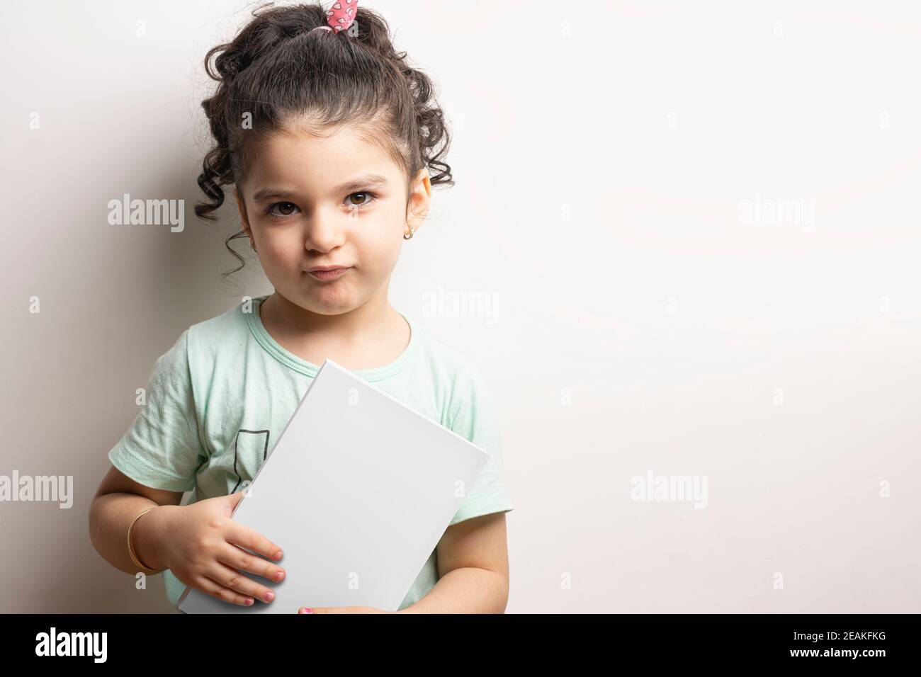 Bambina che tiene un libro con copertina vuota davanti della serie di modelli per il corpo Foto Stock