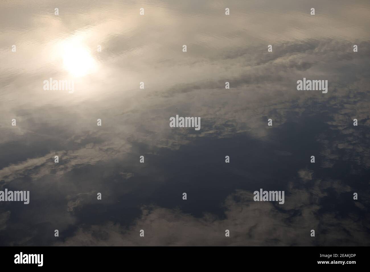 Riflesso astratto della cornice piena del cielo e delle nuvole illuminate dal sole. Foto Stock