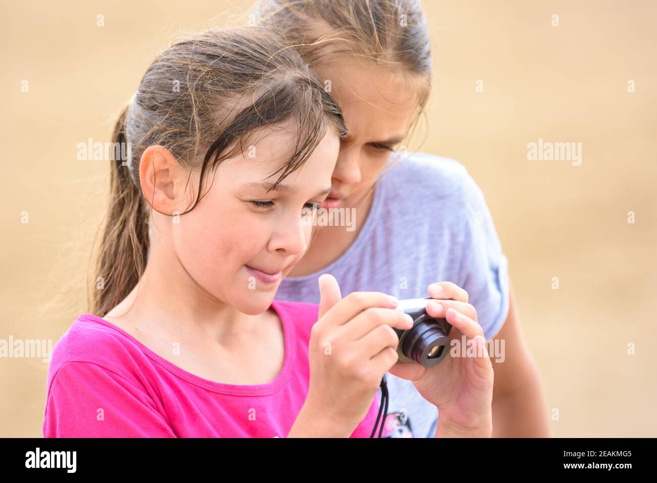 Due ragazze che guardano le foto sullo schermo di un digitale fotocamera Foto Stock