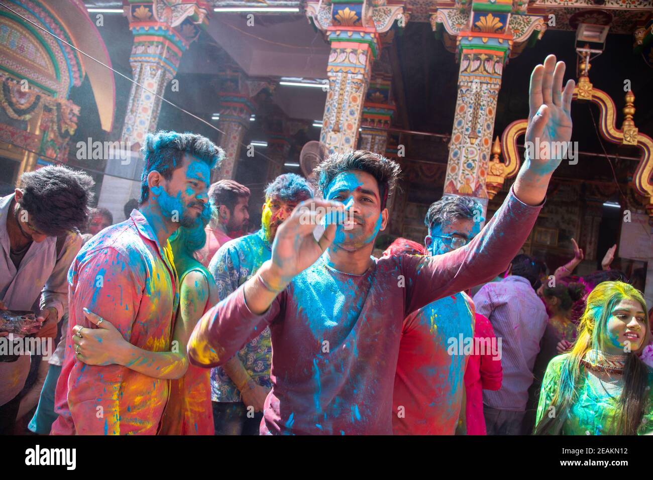 v Gruppo di indiani che ballano e celebrano il festival holi, faccia coperta di polvere colorata. Foto Stock