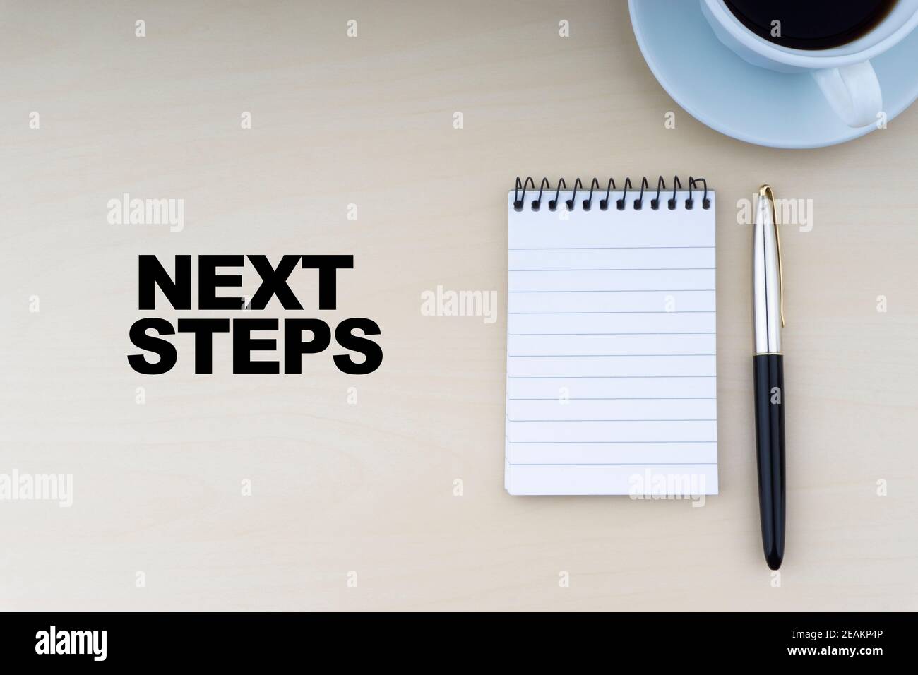 PASSI SUCCESSIVI testo con penna stilografica e tazza di caffè su sfondo di legno Foto Stock