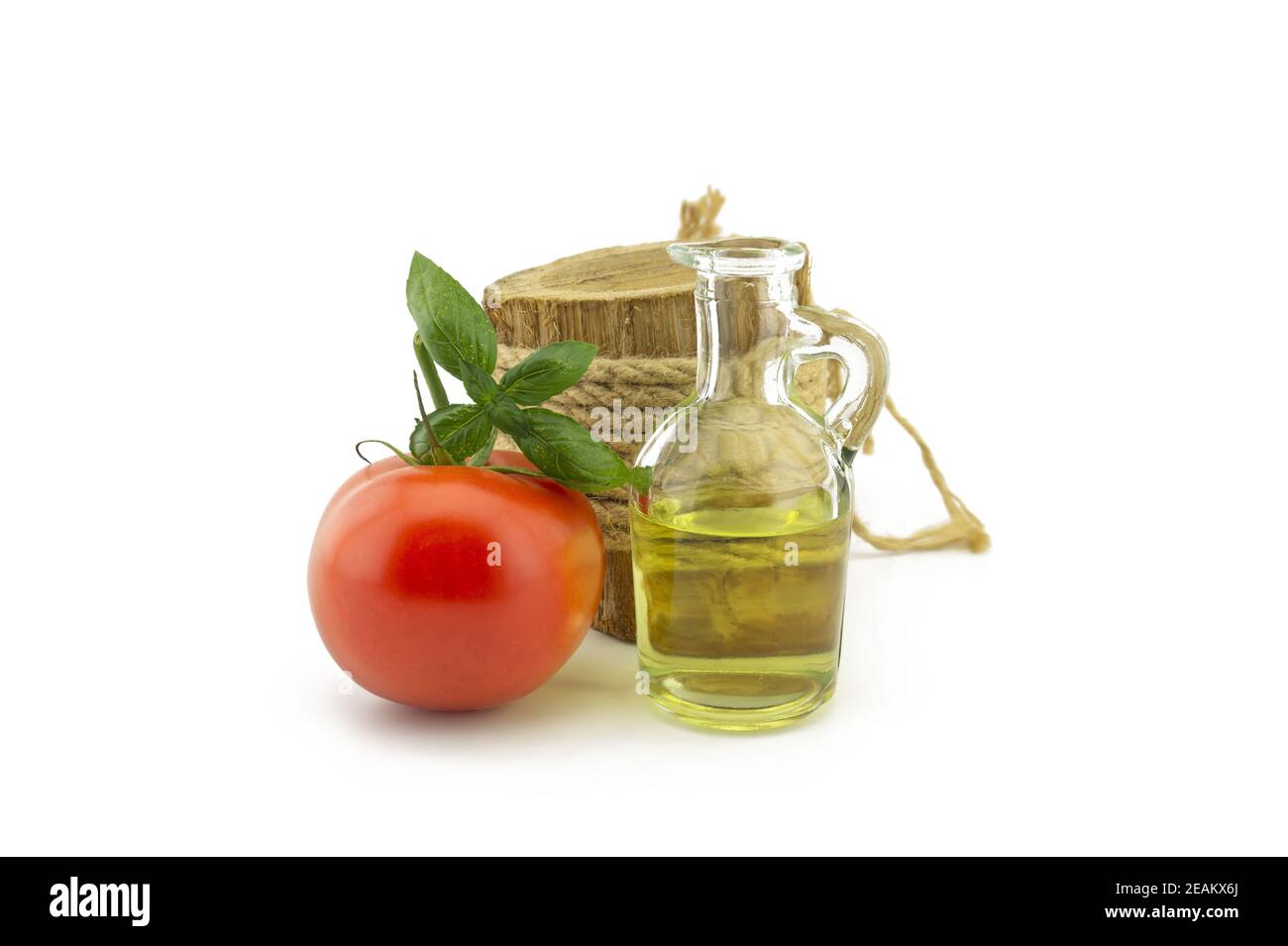 Foglia di pomodoro e basilico e olio in decanter bianco Foto Stock