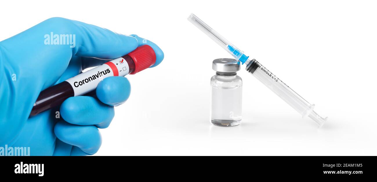 Violo con supporto manuale con campione di sangue di Coronavirus 2019-nCoV. Siringa medica e un bollte con il vaccino sullo sfondo. Foto Stock