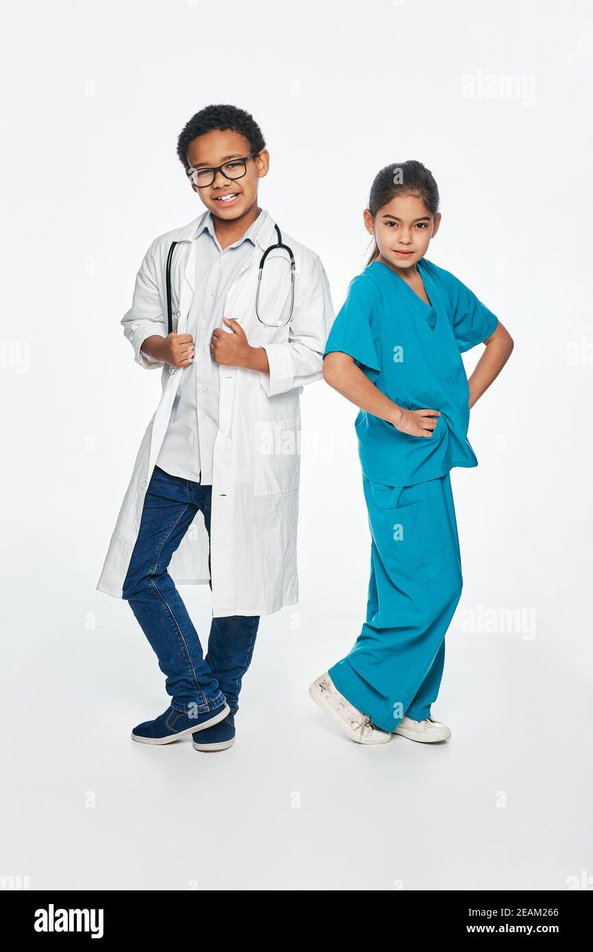 Carino bambini che indossano una divisa medica. Due bambini giocano con il personale medico Foto Stock