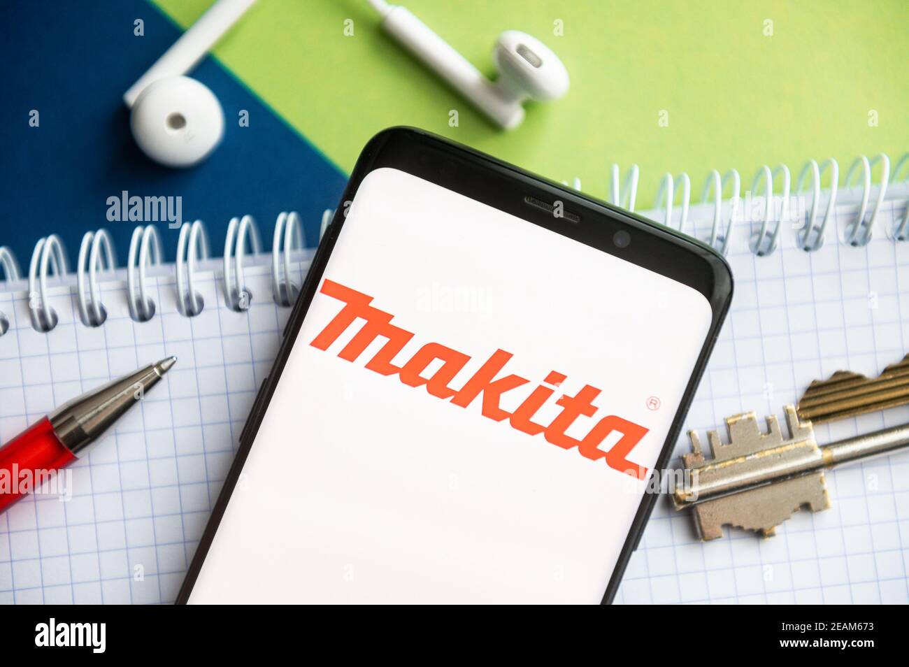 In questa illustrazione fotografica, viene visualizzato un logo Makita su  uno smartphone con una penna, una chiave, un libro e un auricolare sullo  sfondo Foto stock - Alamy