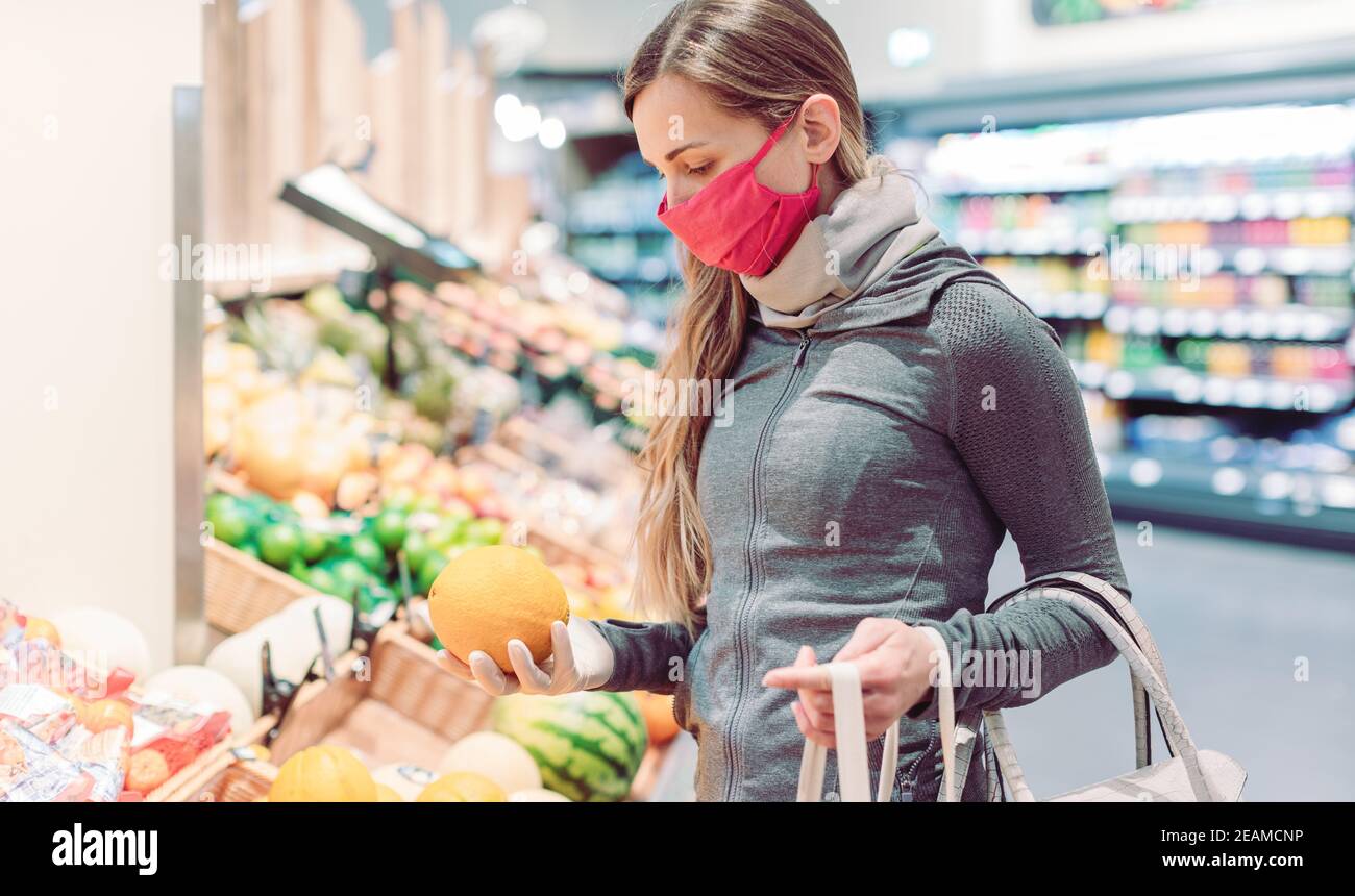 Donna che acquista in supermercato durante il blocco di coronavirus Foto Stock