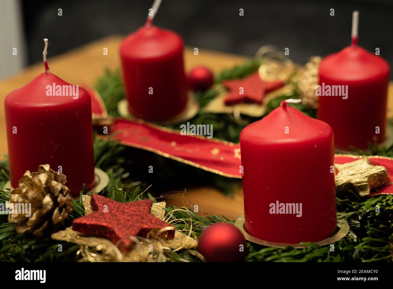 le candele rosse bruciano con le candele su una corona dell'avvento Foto Stock