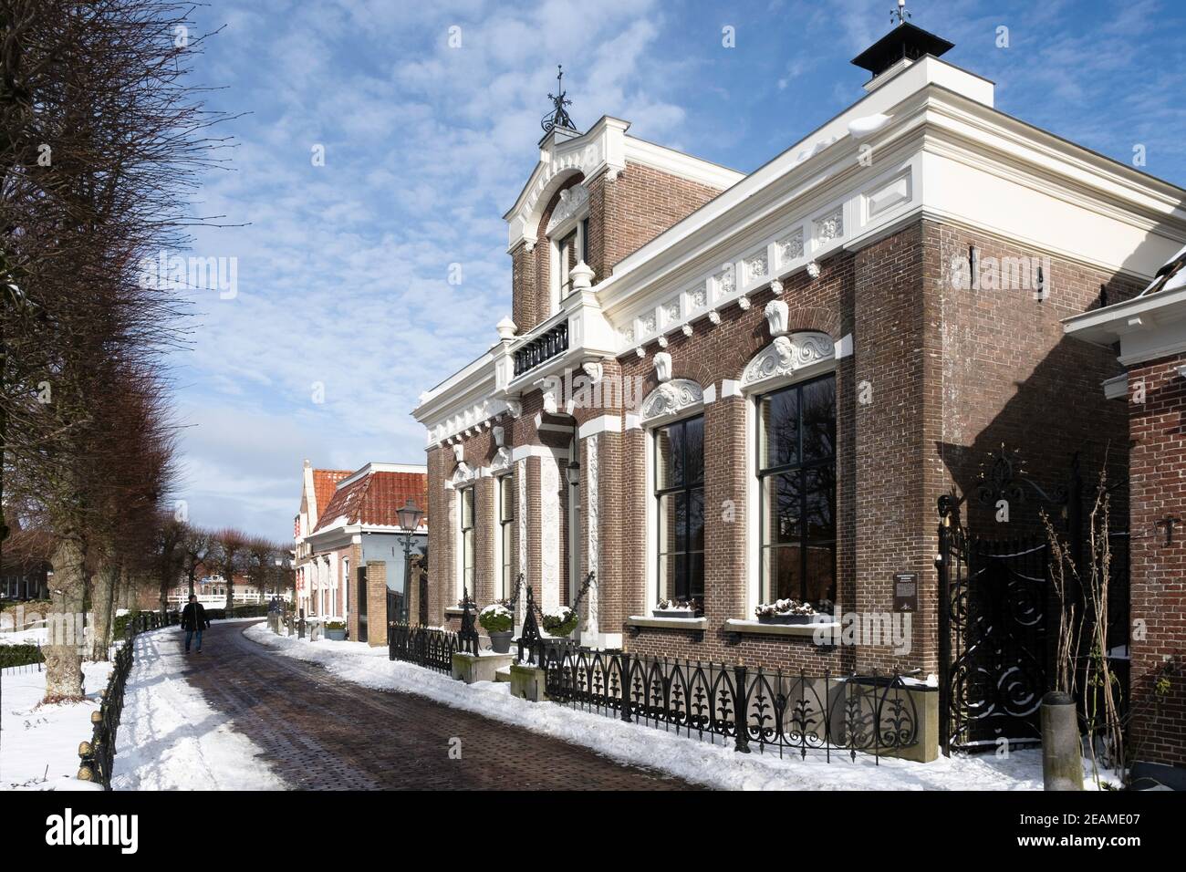 Ex residenza del sindaco nella città Frisia di IJlst nei Paesi Bassi in inverno con neve, sole e cielo blu Foto Stock