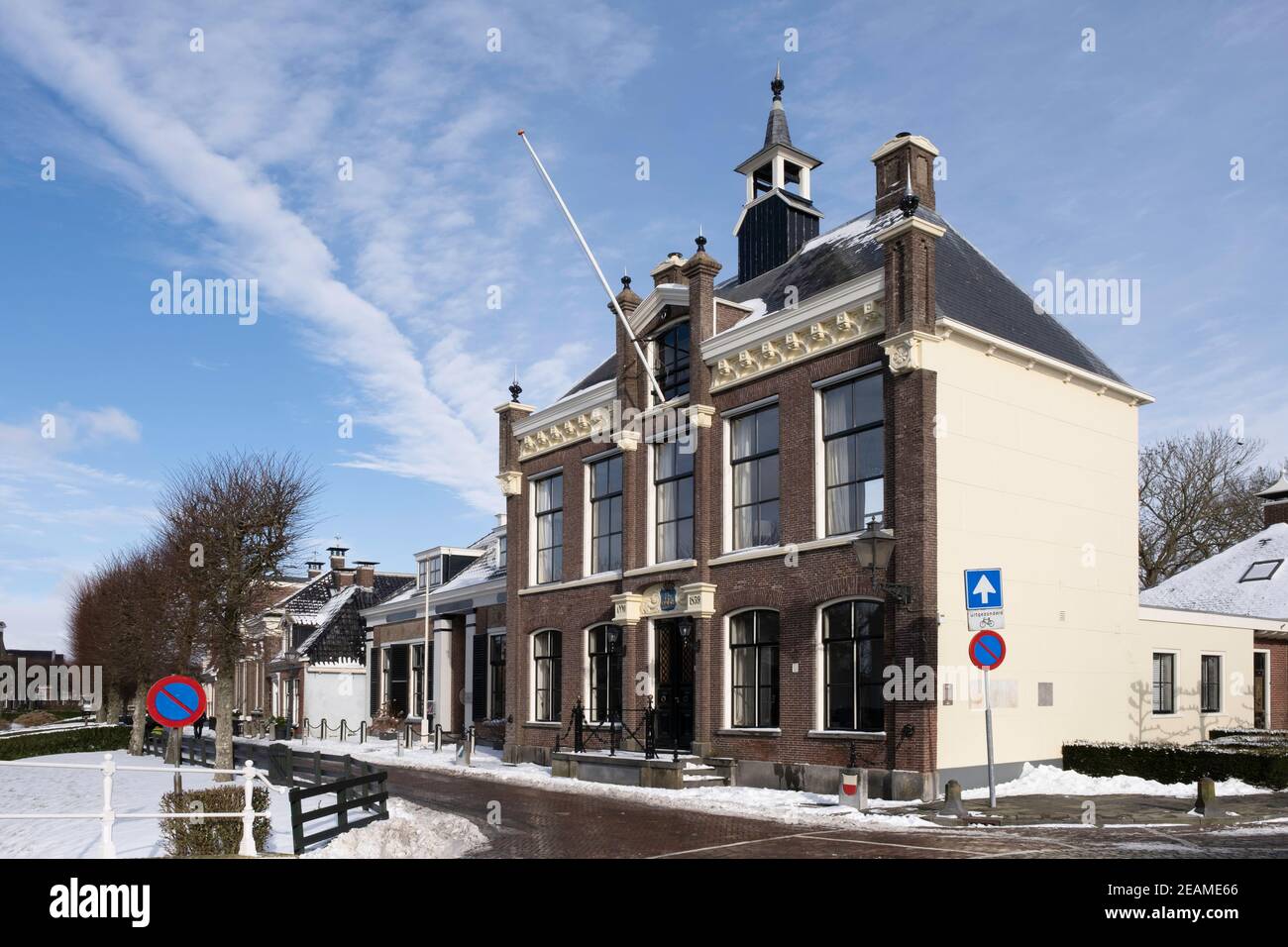 Ex municipio nel centro della città di IJlst, Frisia nella neve con cielo blu Foto Stock