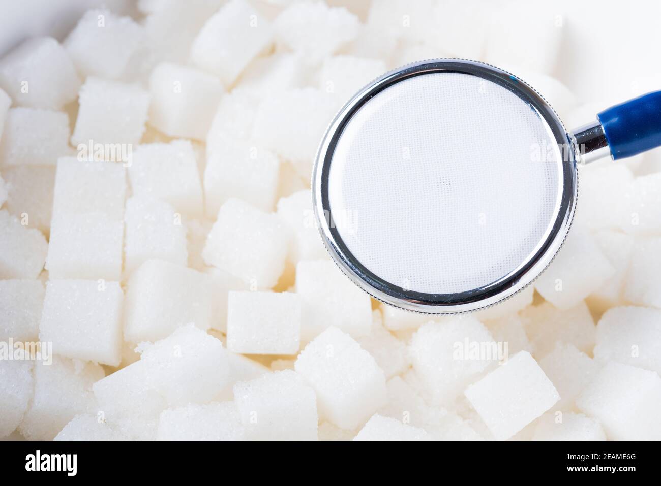 Zucchero cubo di cibo dolce ingrediente di struttura di fondo e stetoscopio medico Foto Stock