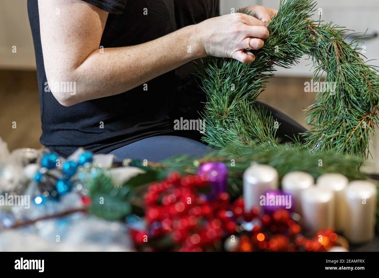 Preparazione fatta a mano della corona dell'avvento da vicino. Foto Stock