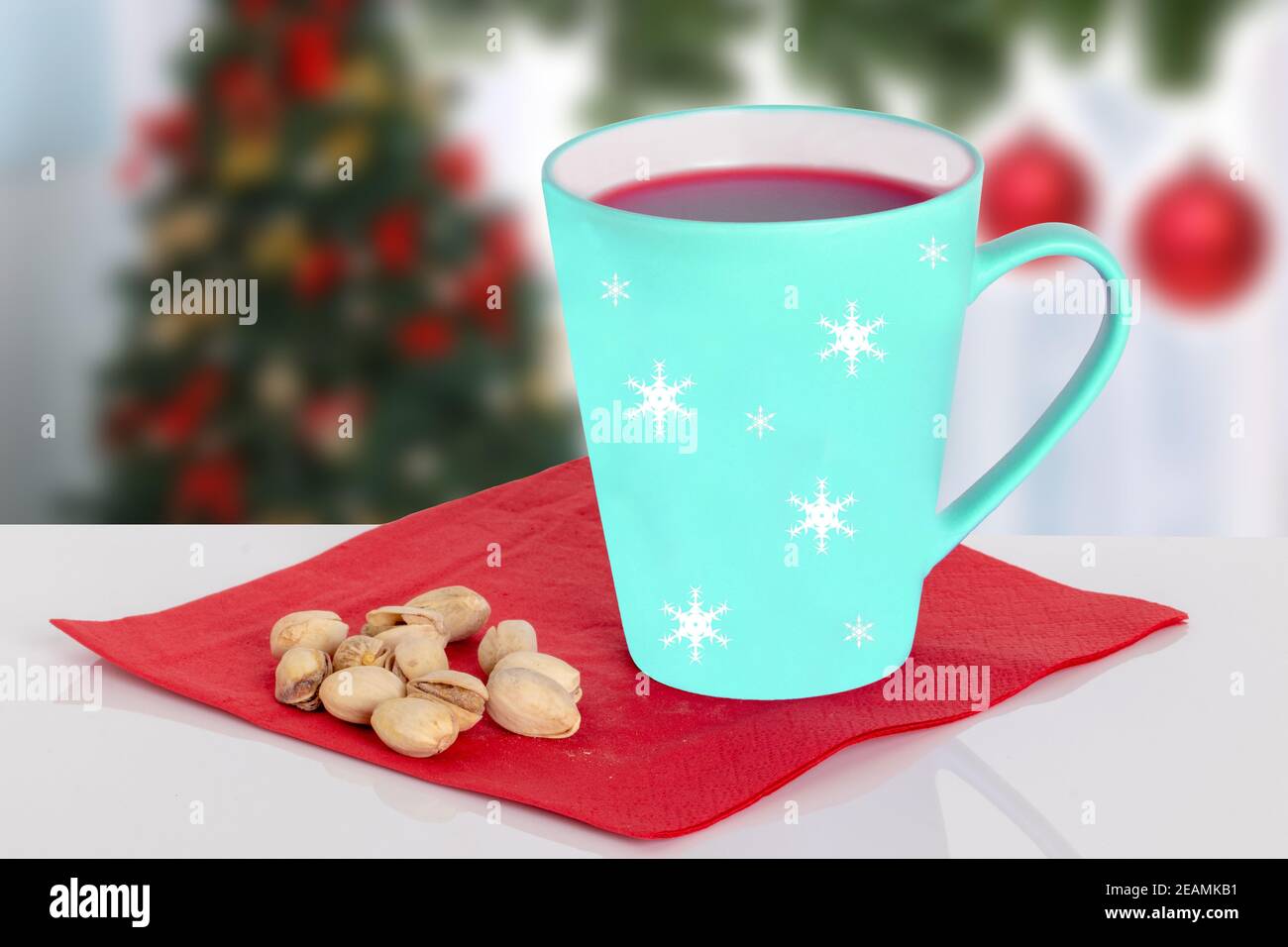 VIN brulé caldo di Natale o punch e pistacchi su un tovagliolo rosso sul tavolo contro uno sfondo di Natale sfocato. Spazio. Foto Stock