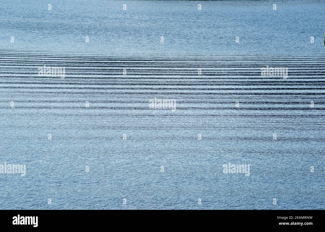 increspature orizzontali sulla tranquilla superficie blu dell'acqua Foto Stock