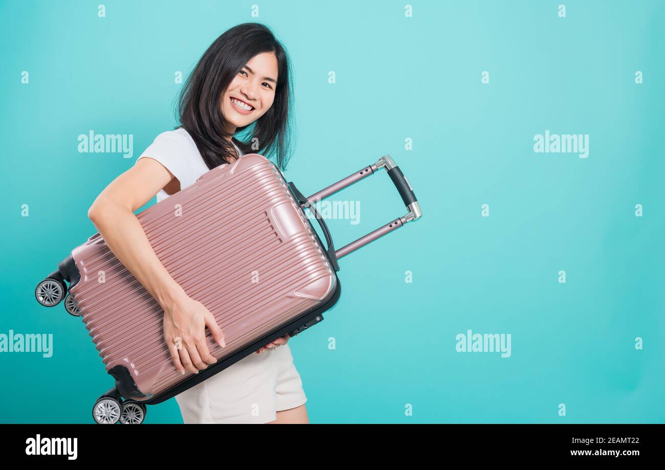 donna in piedi indossare t-shirt bianca, concetto di viaggio vacanze, la sua valigia hugging Foto Stock