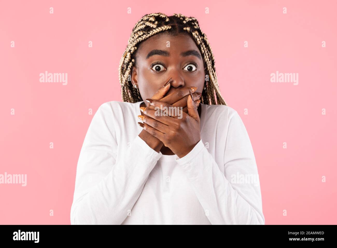 Sorprende la giovane afroamericana che ricopre la bocca con le mani Foto Stock