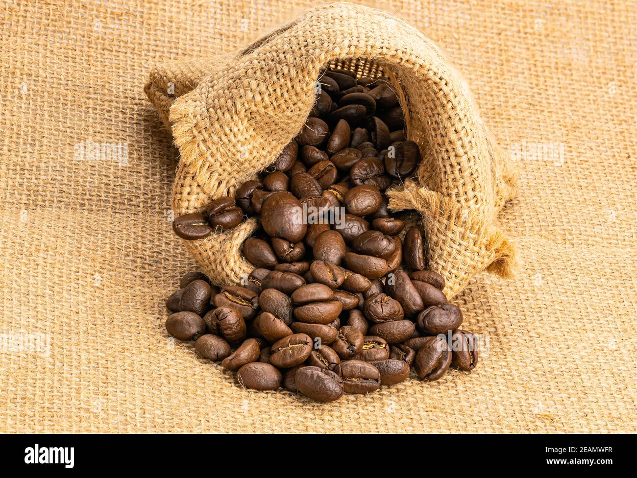 Chicchi di caffè in un sacco su sacco. Chicchi di caffè tostati in un sacchetto. Foto Stock