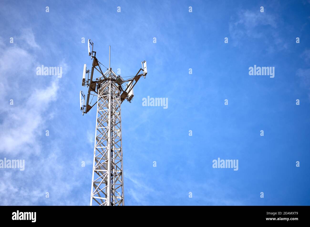 particolare di una torre metallica con antenne di comunicazione telefonica, radio e tv su un cielo blu e nuvoloso Foto Stock