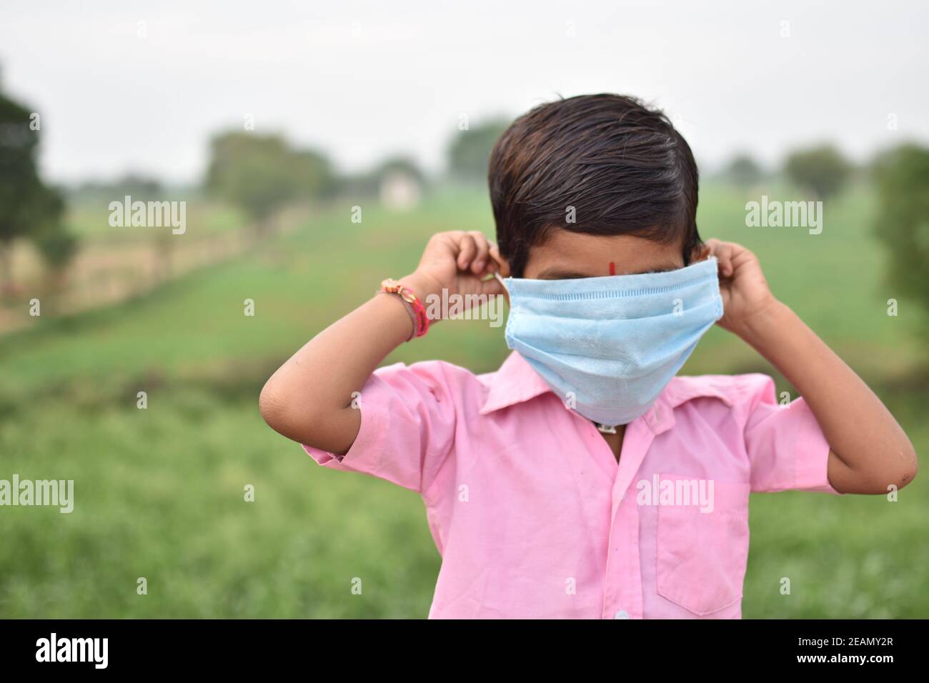 Fuoco selettivo di un ragazzo che indossa una maschera sanitaria troppo grande per il suo volto Foto Stock