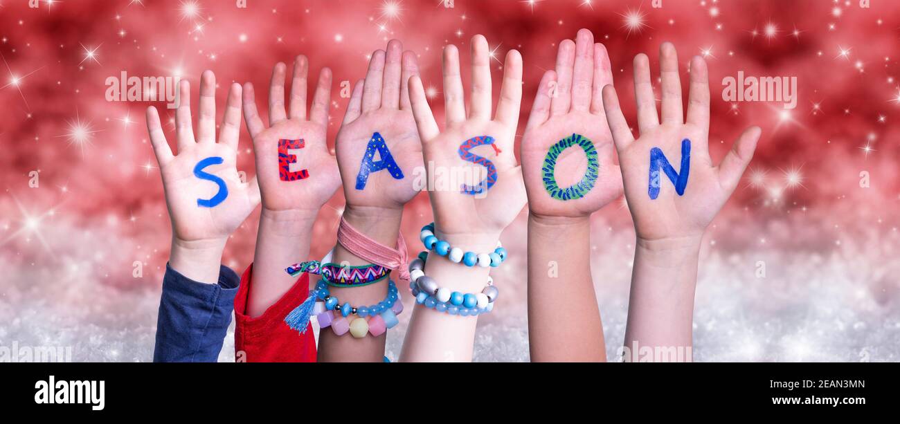 Bambini mani costruire Parola Stagione, Natale rosso sfondo Foto Stock