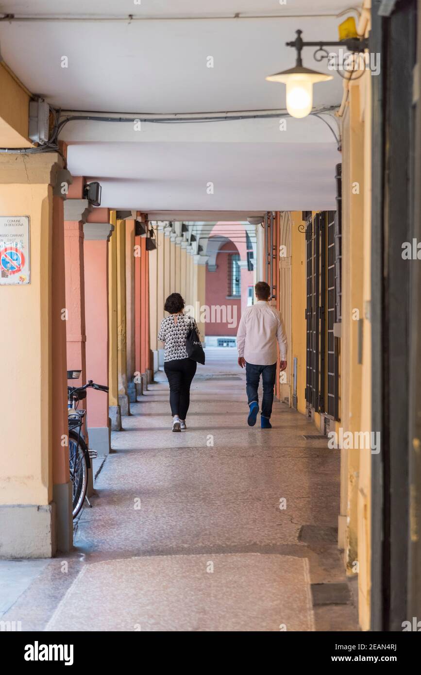 Persone che camminano sotto un portico o una passerella coperta a Bologna Italia Foto Stock