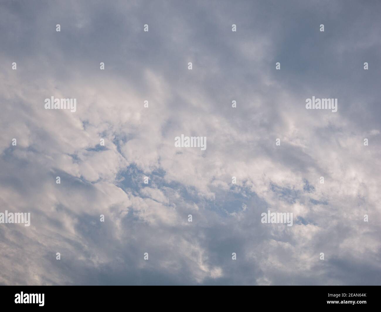 Le nuvole bianche e grigie coprono il cielo blu Foto Stock
