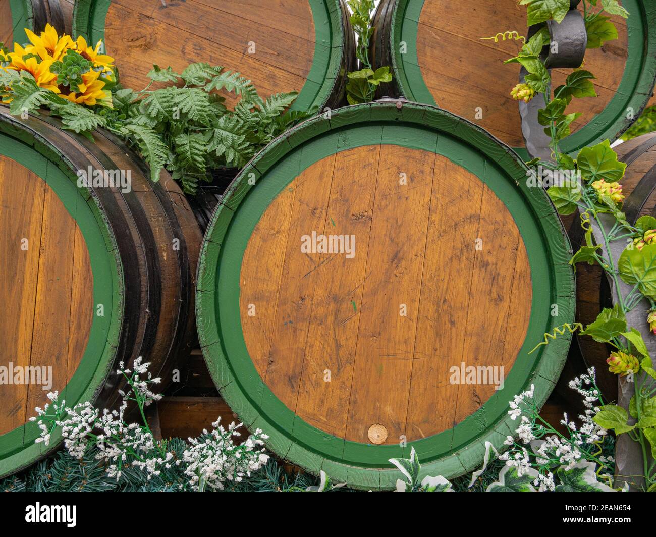 Botti di vino in legno impilate con decorazione floreale Foto Stock