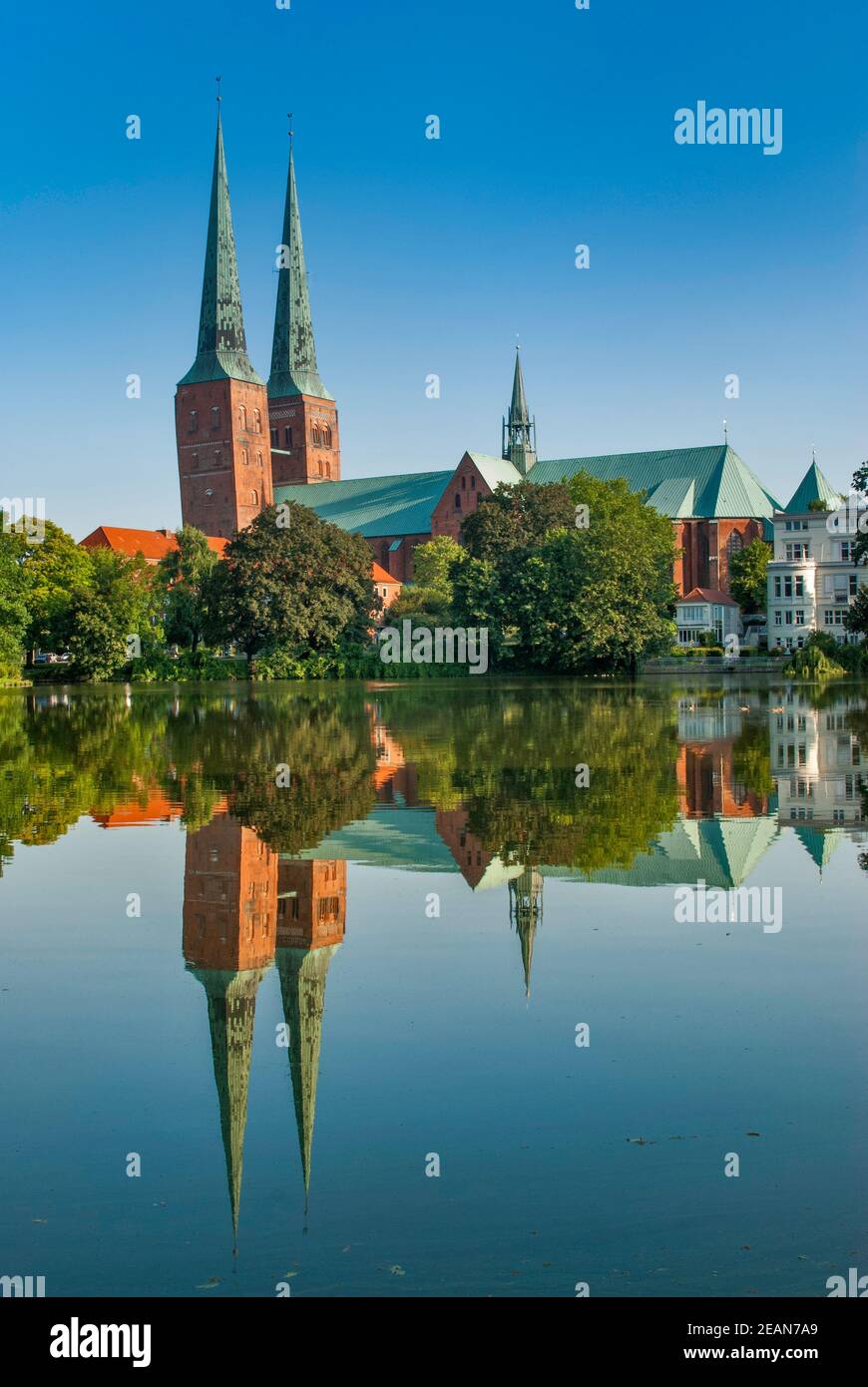 Torri pendenti della Cattedrale specchiate dall'acqua del lago Mühlenteich a Lübeck in Schleswig-Holstein, Germania Foto Stock