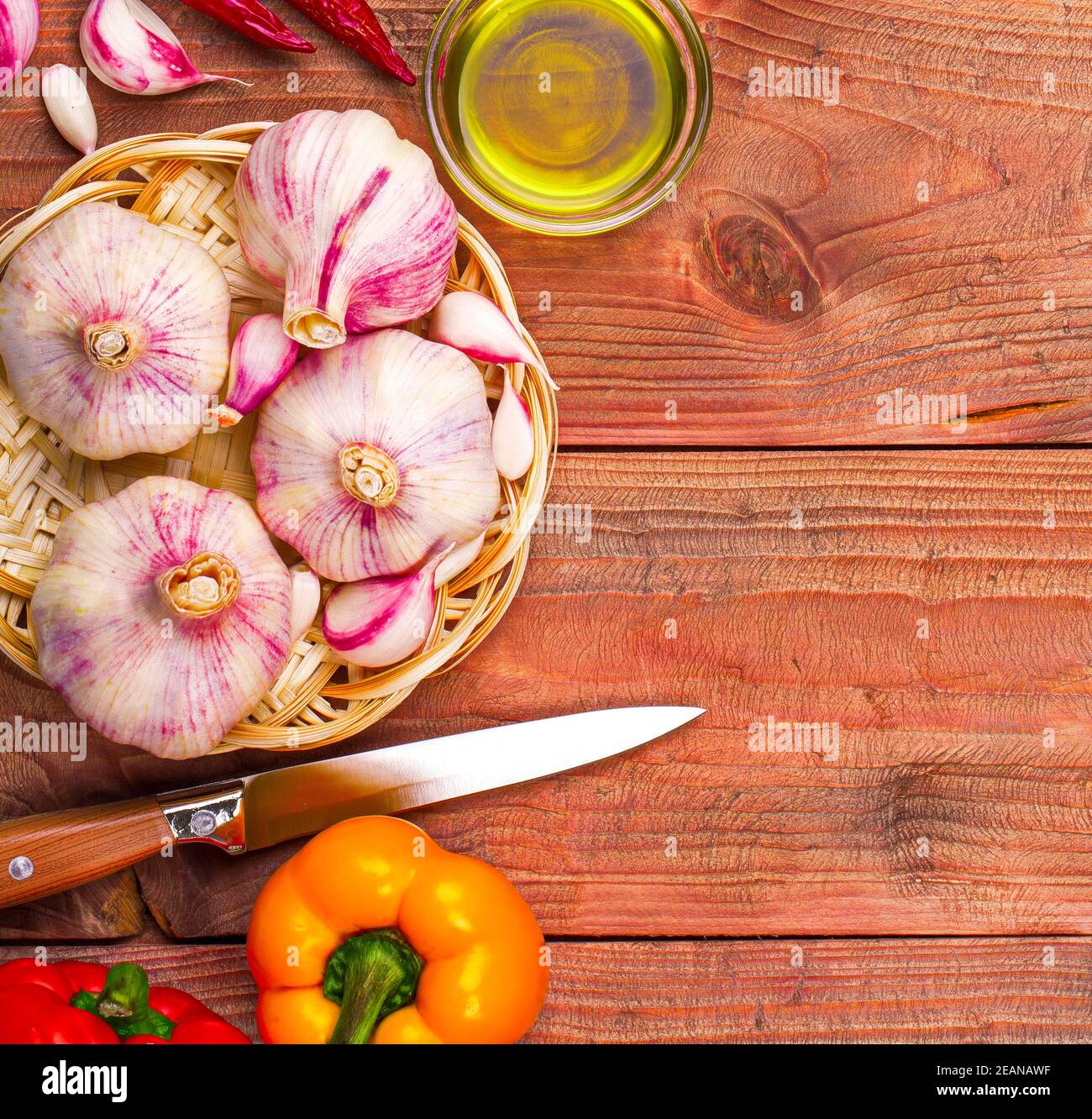 Fondo culinario aglio, pepe su un tavolo di legno Foto Stock