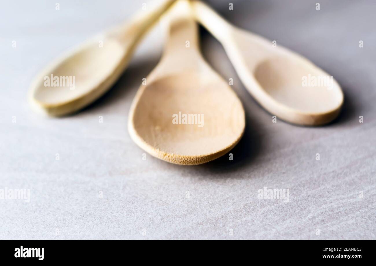 Gruppo di cucchiai da cucina in legno disposti su un marmo grigio tabella Foto Stock