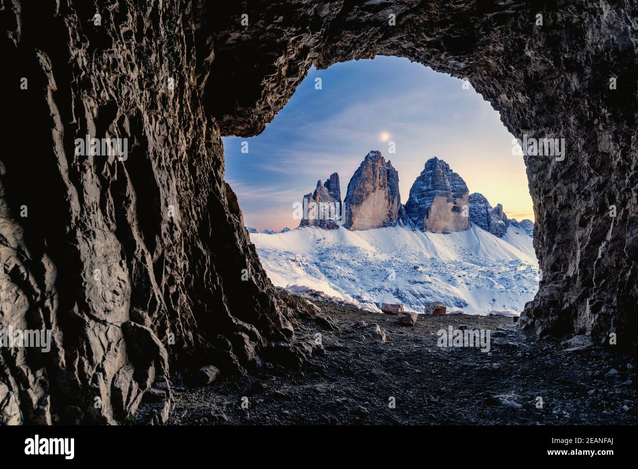 Tre Cime di Lavaredo illuminato dalla luna vista dall'apertura in rocce di una grotta di guerra, Dolomiti di Sesto, Trentino-Alto Adige, Italia, Europa Foto Stock