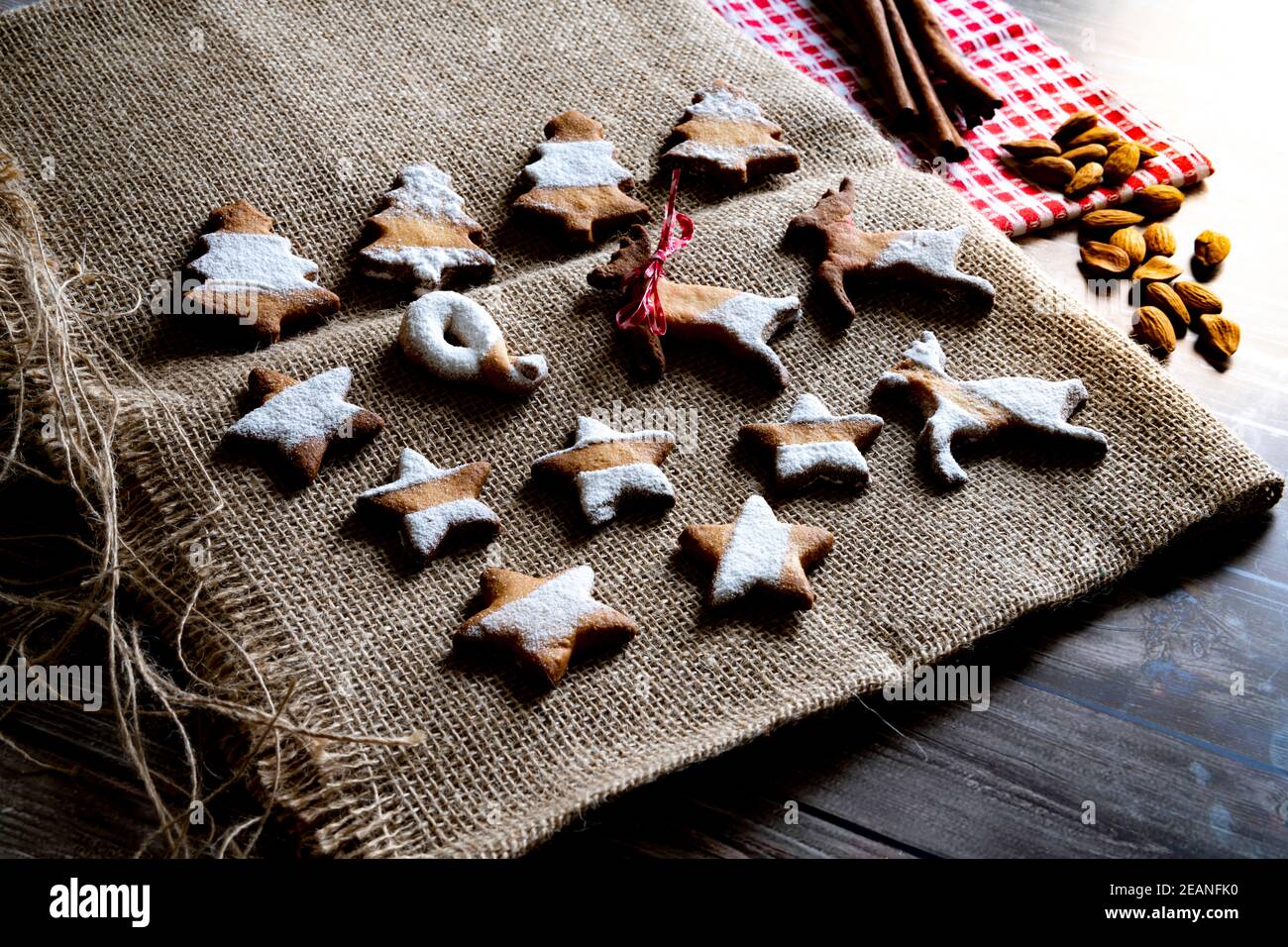 Biscotti di pan di zenzero e burro a forma di albero di Natale, stelle e renne su tela posto tappeto su tavola di legno sfondo, Italia, Europa Foto Stock