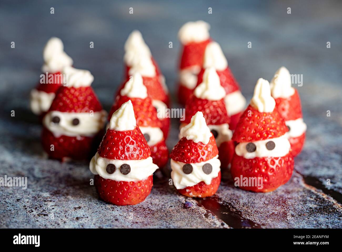 Graziose fragole decorate a forma di Babbo Natale ripieno di panna montata a Natale, Italia, Europa Foto Stock