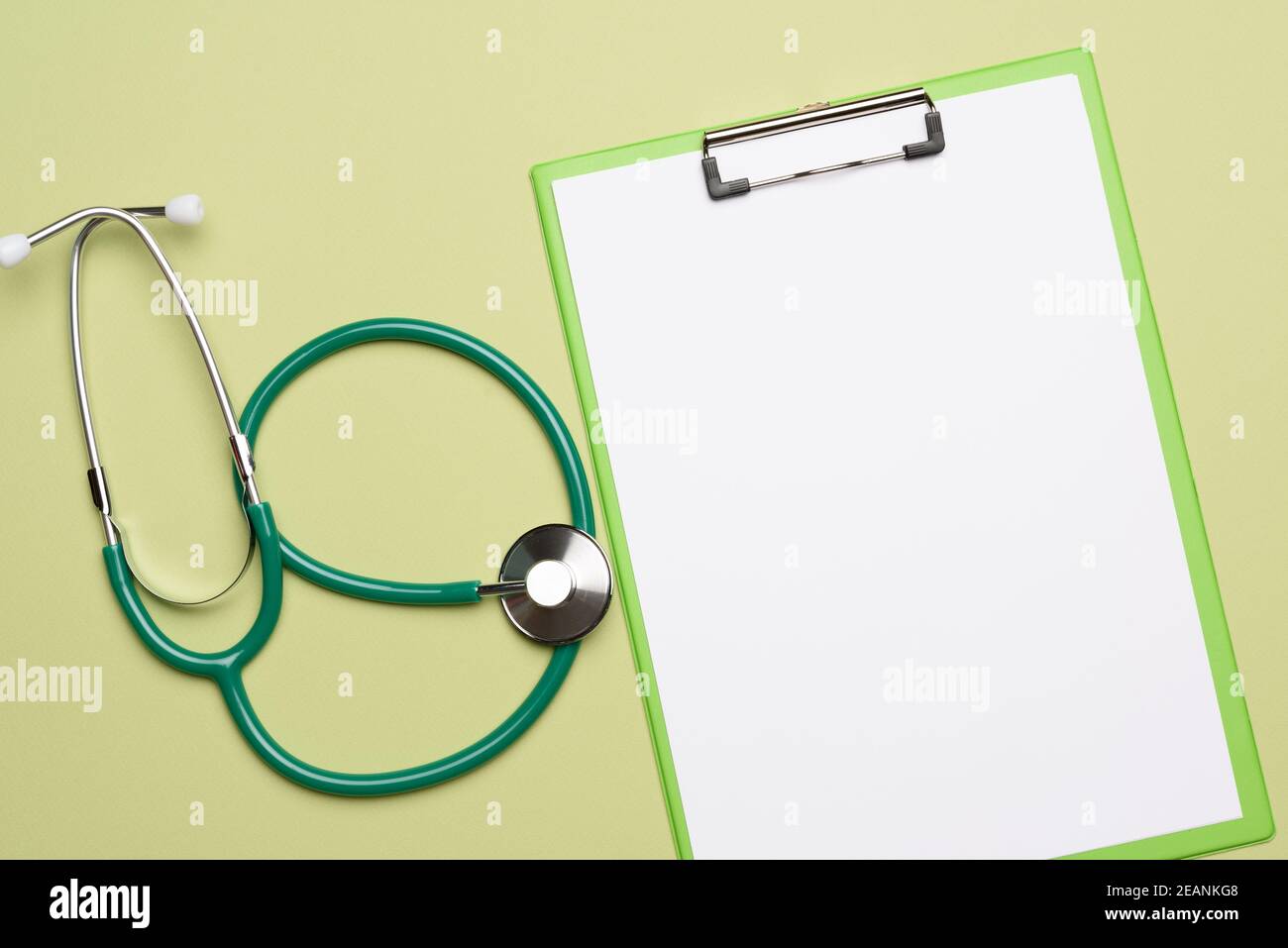 stetoscopio medico e porta fogli di carta su sfondo verde Foto Stock