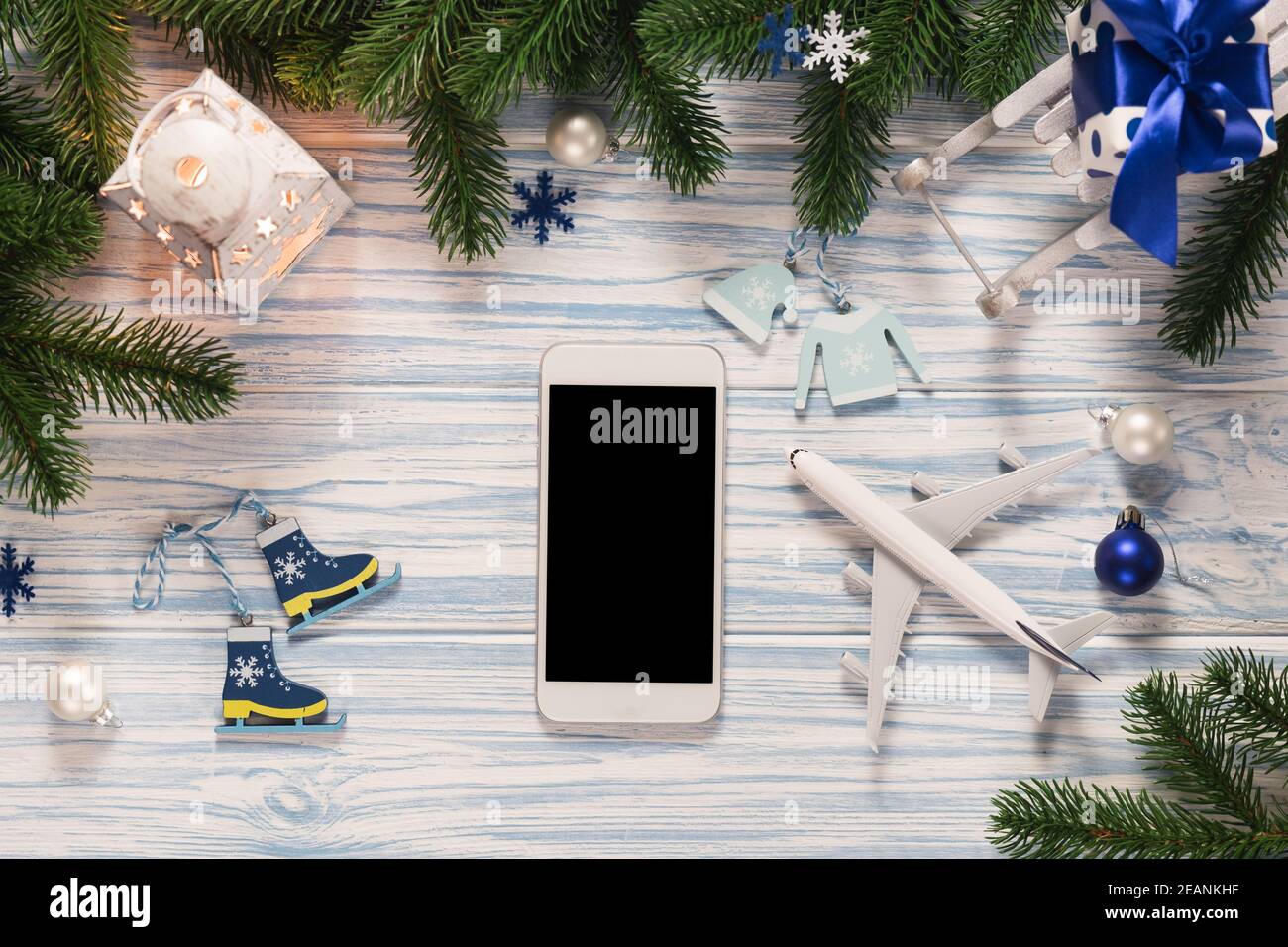 Pianificazione dei viaggi di Natale o Capodanno. Smartphone a schermo vuoto mockup con modello aereo. Foto Stock