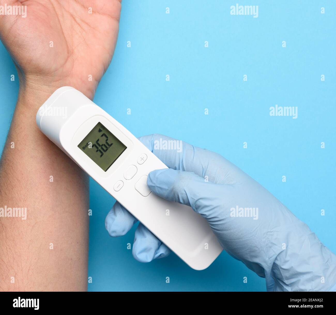 il processo di misurazione della temperatura corporea sul polso con un termometro senza contatto Foto Stock