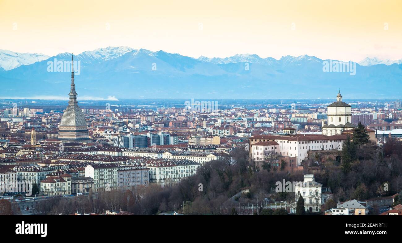 Skyline panoramico di Torino al tramonto con le Alpi sullo sfondo Foto Stock