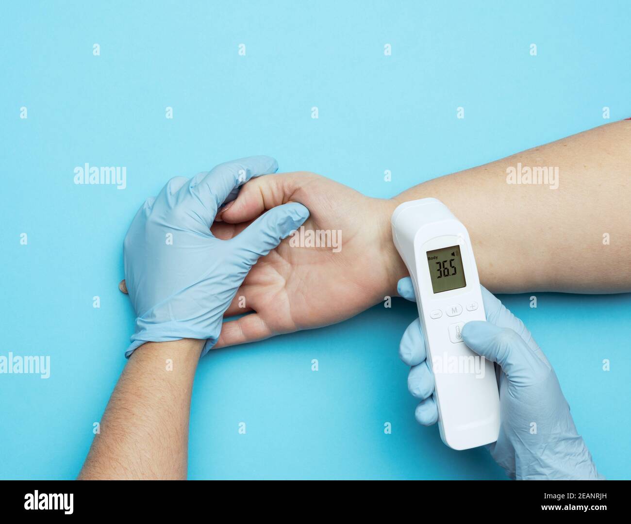 processo di misurazione della temperatura corporea sul polso con un termometro senza contatto Foto Stock